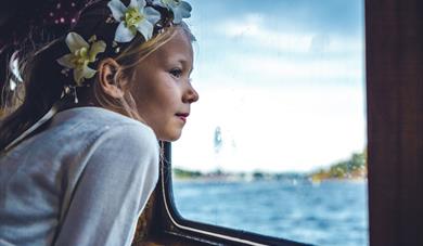 jente ser ut av vinduet på båten