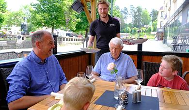 En familie får servert mat på uteserveringen til EYDE Bar & Restaurant i Notodden. Foto